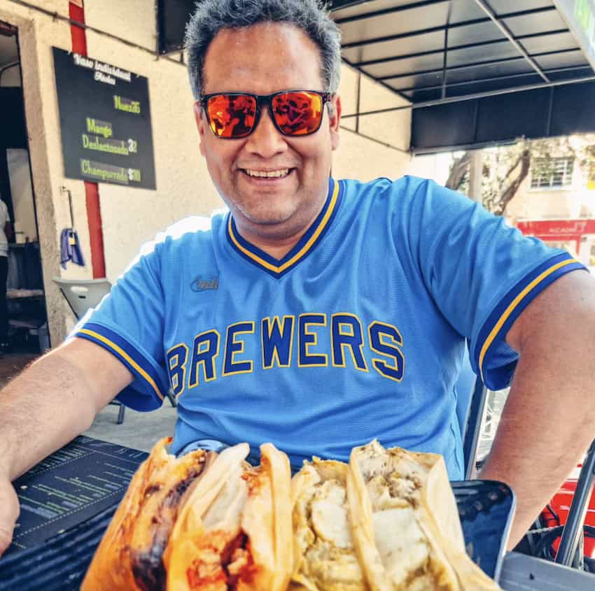 A man enjoying Doña Emi tamales on a Mexico City food tour